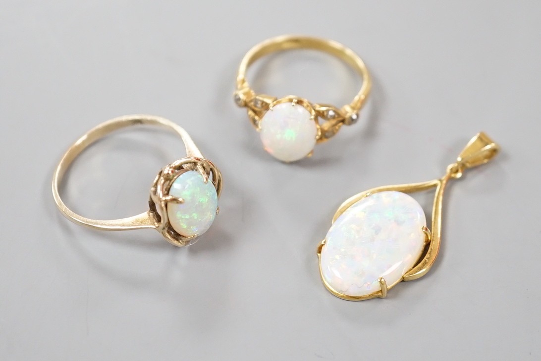 A 9k yellow metal and oval white opal set ring, size O, gross 2.1 grams, an 18ct yellow metal and oval white opal ring, with diamond chip set shoulders and a 70 and white opal set pendant, gross 5.2 grams.
